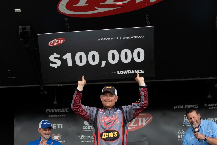 Andrew Upshaw holding up FLW winnings check