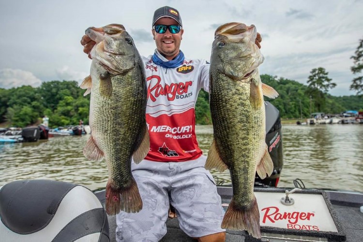 Cole Floyd holding out two fish caught during a tournament