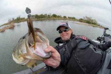Keith Combs holding up a bass hooked on the Thunder Cricket